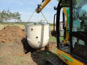 Sewage treatment plant being lowered into excavation