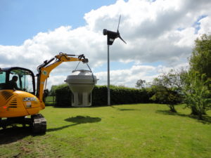 sewage treatment plant transported by excavator to the back garden
