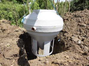 sewage treatment plant being lowered into excavation