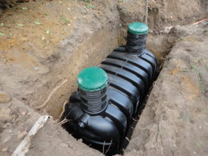 septic tank lowered into excavation and sitting on base